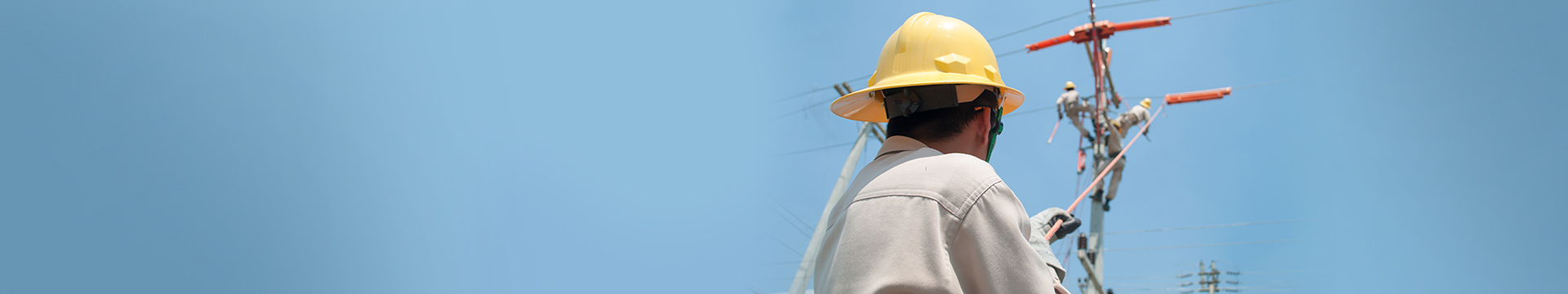 Group of electrical workers fixing the wire by climbing on the pole